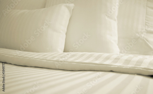 Foto: Bed with set of crisp striped sheets and pillows Bed with set of crisp striped sheets and pillows