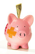 Piggy bank with bandage and a dollar Piggy bank with bandage and a dollar