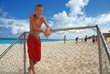 Boy standing at beach goalpost