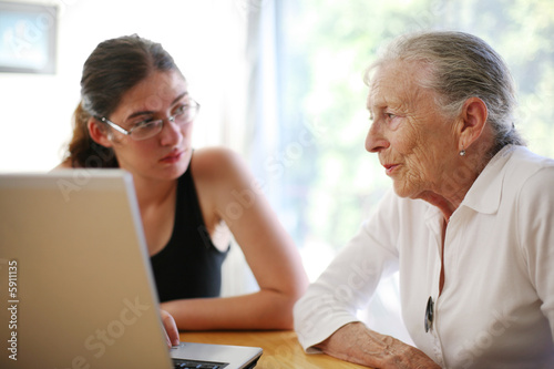 Grandmother and granddaughter with laptop.