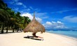 Straw huts on white sand beach