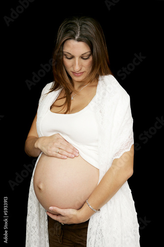 Beautiful Pregnant woman holding her belly. Black background. Beautiful Pregnant woman holding her belly. Black background.