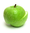 The wet green apple is cut on two parts