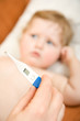 Foto: Doctor with baby and reading thermometer gauge. Doctor with baby and reading thermometer gauge.