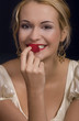 Beautiful blond girl kissing and smelling a rose petal 