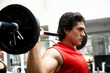 man lifting weights at the gym looking serious