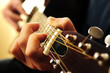 Hands of a person playing an acoustic guitar close up