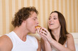 Pretty young couple having breakfast in bed