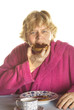 senior woman is eating biscuits while having breakfast
