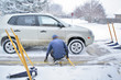 Photo: Man servicing car tires in the snow Man servicing car tires in the snow