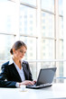 Portrait of business woman sitting at the table and typing 