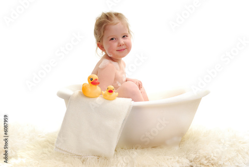 Photo: A young girl with bubbles in bathtub. A young girl with bubbles in bathtub.