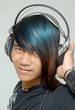 Asian teenager portrait with headphones enjoying music