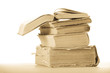 Opened book on stack of old books. White background. Opened book on stack of old books. White background.