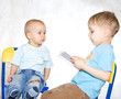 Kid reading book to brother. White window background