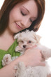 Prett Woman holding a cute, small maltese dog