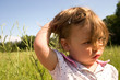 a little girl trying to hold her hair back from the wind