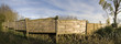 A wooden fence dividing two properties, houses yards.