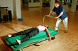 Man pulling woman on mat trolley