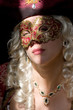 Foto: Tempting woman in renaissance mask with emerald necklace. Tempting woman in renaissance mask with emerald necklace.