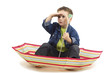 Boy sitting in an umbrella, playing like it's a boat.
