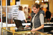 Young businesswoman using laptop computer at trade show.
