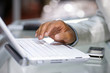 Close-up of male hand typing on white laptop computer