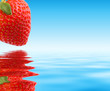 Red strawberry over blue water. Macro, close-up. Red strawberry over blue water. Macro, close-up.