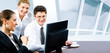 Team of business people looking at monitor of computer