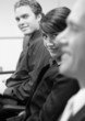 woman and two men looking at camera in boardroom meeting