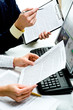 Close-up of businesspeople’s hands holding documents 