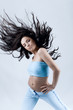 young woman dancing, hair flying, studio shot