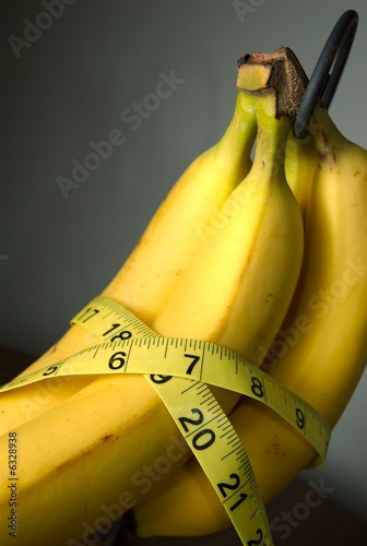 Photo: Measureing tape around some bananas. Measureing tape around some bananas.