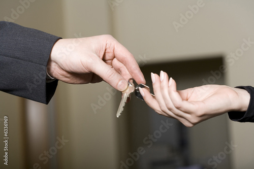 Photo: a man gives keys to a woman a man gives keys to a woman