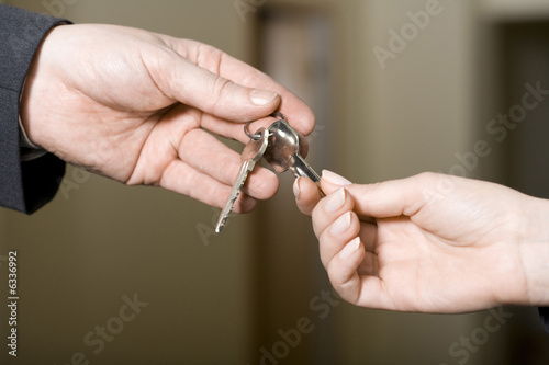 Photo: a man gives keys to a woman a man gives keys to a woman
