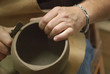 Two male hands working on a pottery piece Two male hands working on a pottery piece