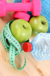 sports equipment - dumbbells water and green apple