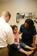 White Doctor and Hispanic nurse check young child