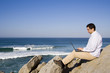 young man working with the laptop at the beach