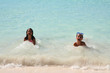 Young girl playing in the sand at the beach with her brother Young girl playing in the sand at the beach with her brother