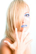 Blonde Frau mit Hand vor Gesicht und blauen Lippen
