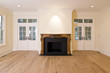 livingroom with intricately carved fireplace and lots of window