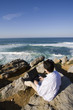 young man working with the laptop at the beach