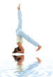 sporty girl practicing supported headstand on white sand
