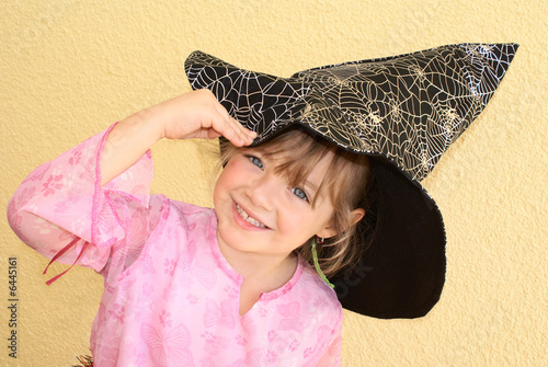 Photo: Five-year-old girl keeps witches hat in his hand. Halloween. Five-year-old girl keeps witches hat in his hand. Halloween.