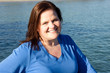 Beautiful plus-sized model posing by the water.