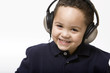Boy listening to music with headphones on a light background