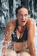 A young woman under a waterfall at a luxury resort in Costa Rica