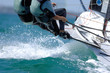 Foto: Sailors splash through the waves during a regatta. Sailors splash through the waves during a regatta.