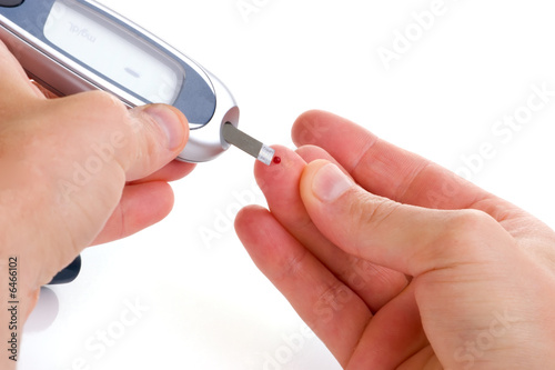 Diabetic is doing a glucose level finger blood test.